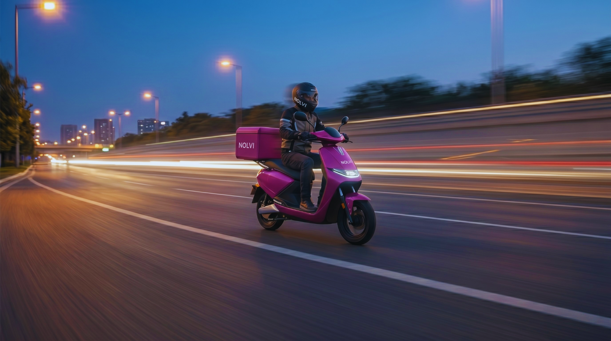 Person riding a pink scooter on a road at night with blurred lights