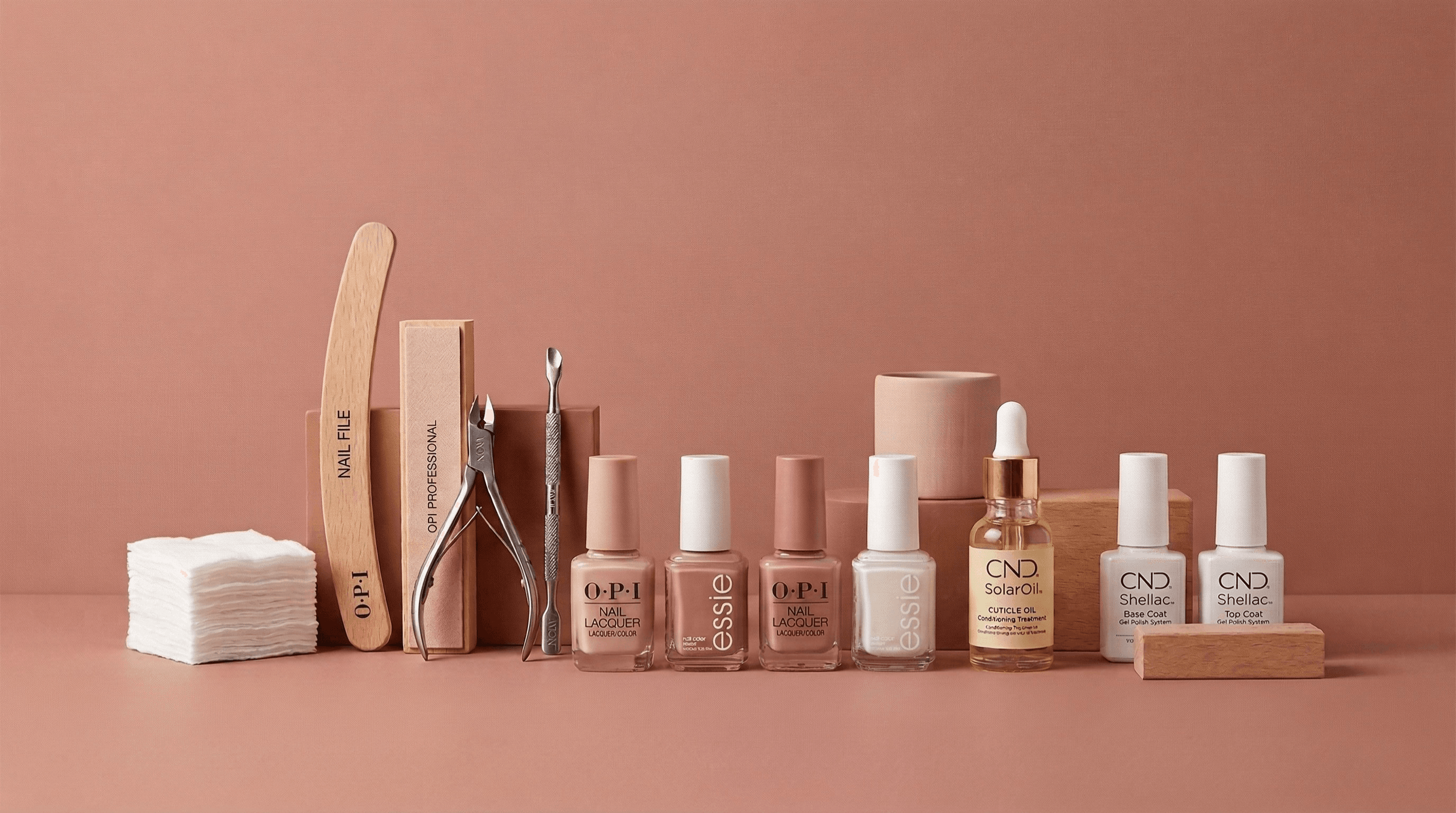 Collection of nail care products including bottles, a file, and other tools on a brown background